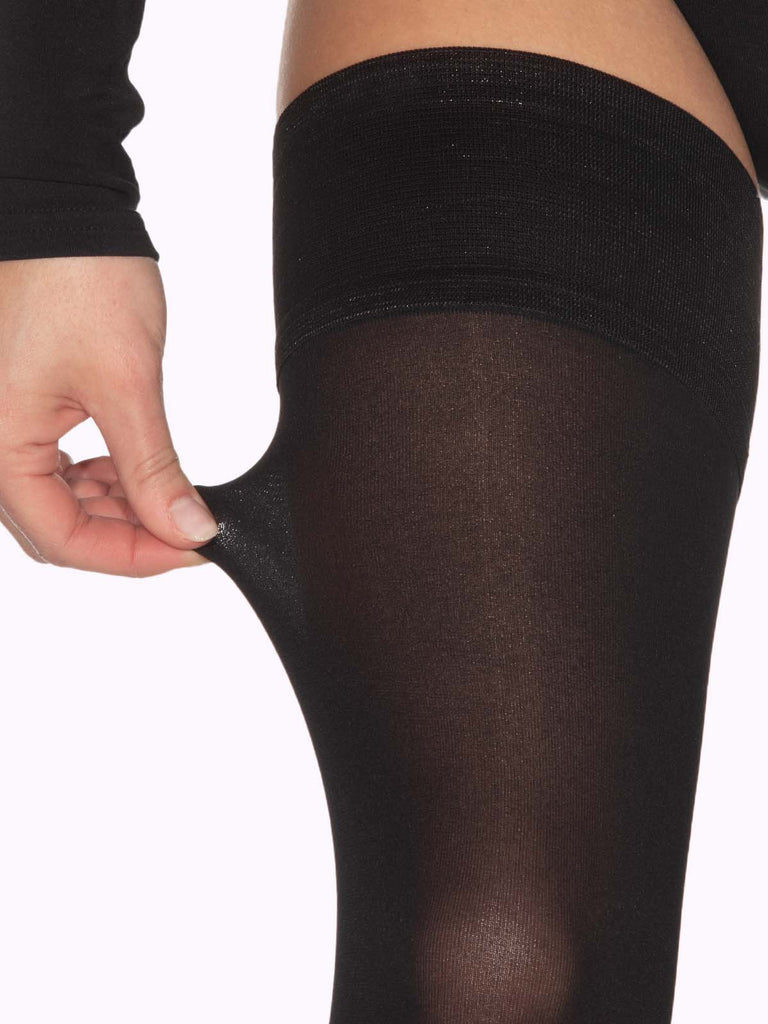 Black matte thigh highs with stay-up silicone bands close up with hand